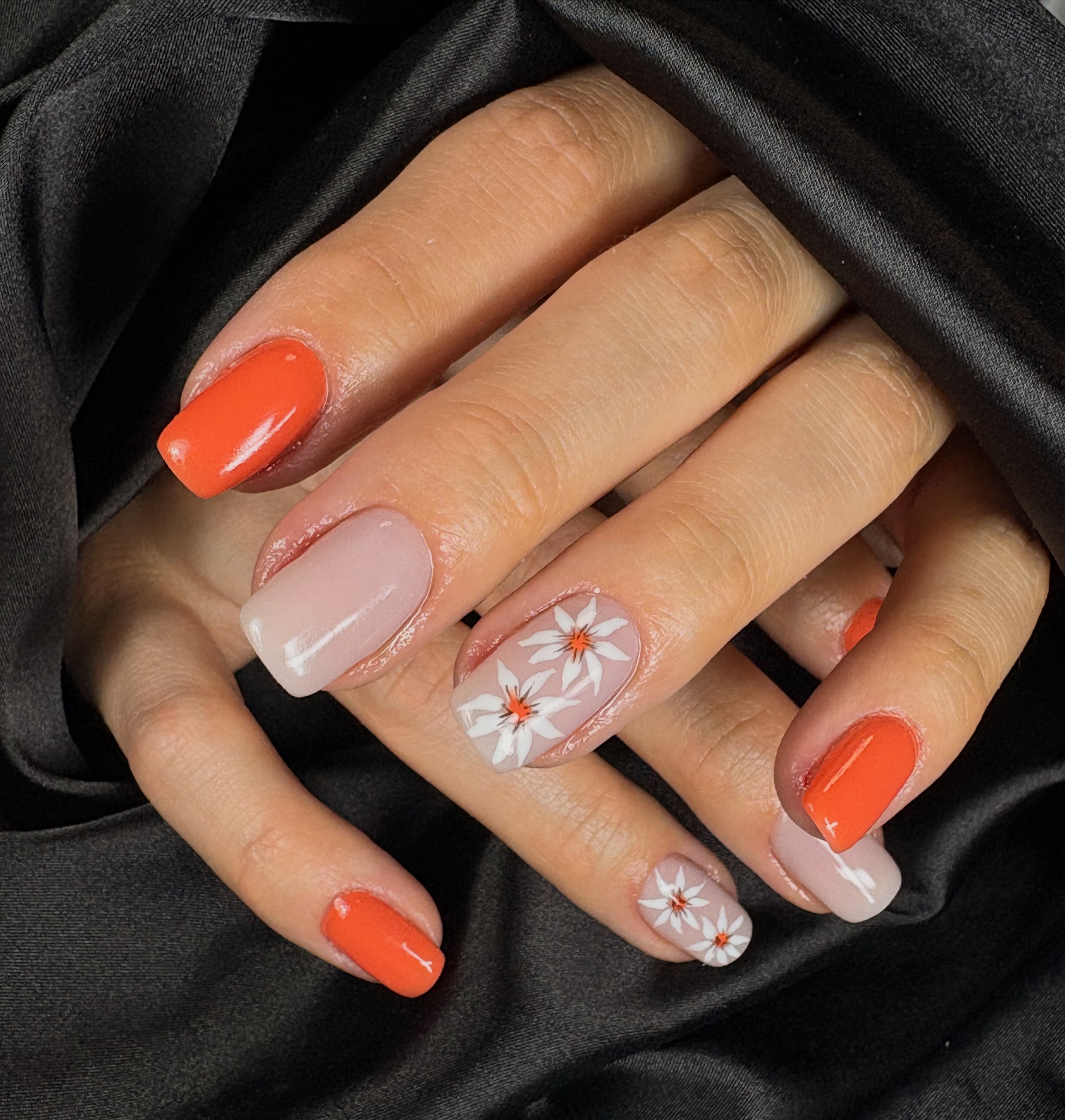 Oranje en nude nagels met witte madeliefjes